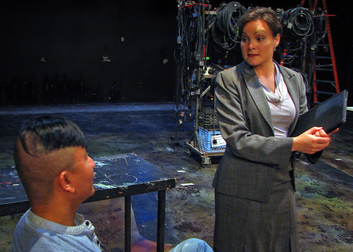 Fabiana Cunningham (Caitlin Frances) interviewing Satan (Ray Tagavilla) in rehearsal for The Last Days of Judas Iscariot.