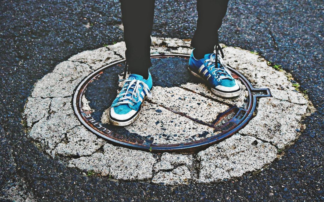 Person standing on a maintenance cover in the street