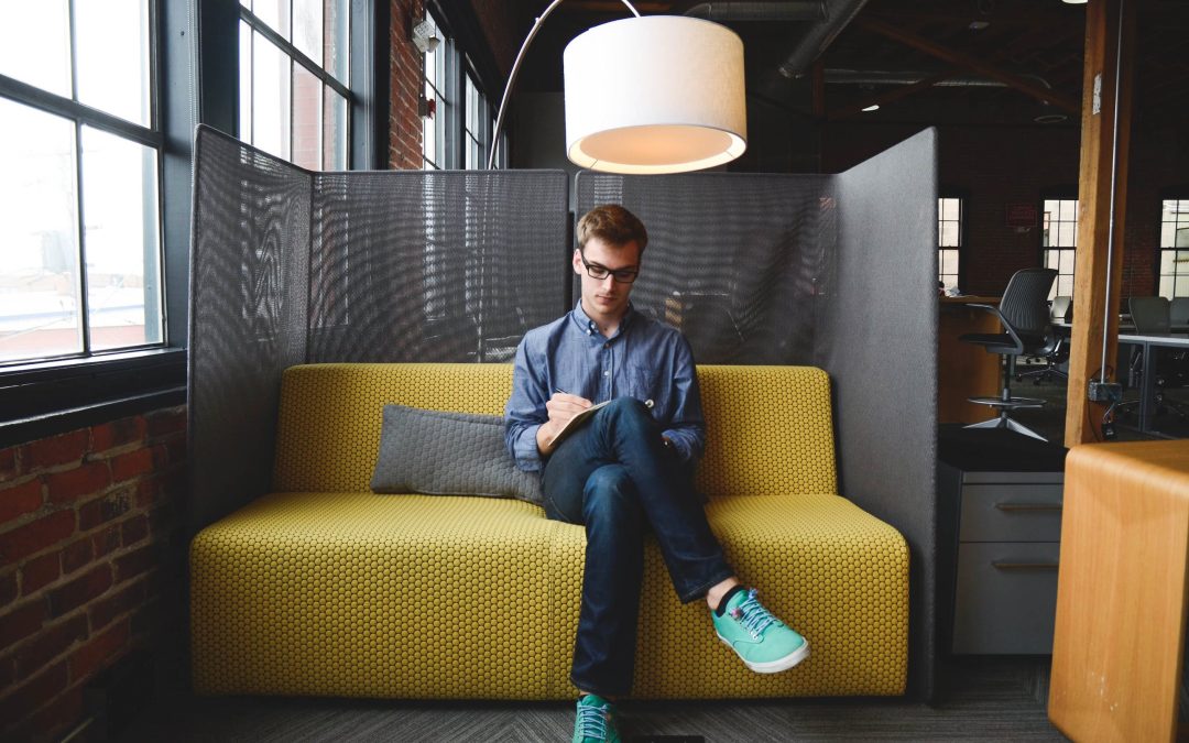 Man Wearing Blue Dress Shirt Sitting on Yellow Sofa