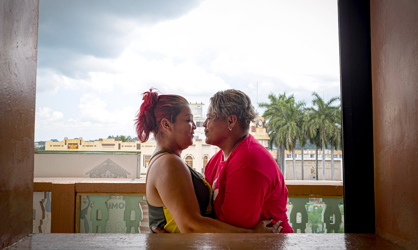 Glenda Diana Cruz, left, and her partner fled San Salvador, El Salvador, after being threatened because of their sexual orientation. Here, they share an intimate moment on the balcony of T’ja Xuj, which overlooks the main plaza in Tapachula